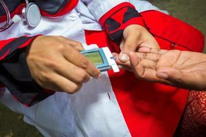 Frau Überprüfung Zucker Niveau mit Glukometer mit ein Blut Stichprobe beim Narsingdi, Bangladesch. lernen zu verwenden ein Blutzuckermessgerät. Konzept von Diabetes Behandlung. foto