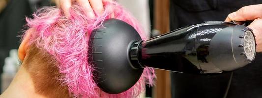 Friseur Trocknen Rosa Haar von Klient foto