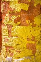 Rot, orange, Gelb und Blau Farbe Kombination alt texturiert Beschädigung Mauer mit bunt Ziegel. foto
