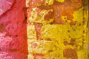 Rot, orange, Gelb und Blau Farbe Kombination alt texturiert Beschädigung Mauer mit bunt Ziegel. foto