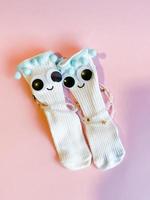 Baby Socken mit Augen und Lächeln auf Rosa Hintergrund foto