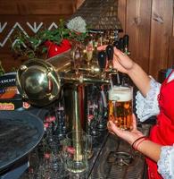 Slowakei, Bratislava - - 01.07.2023 weiblich Barmann Hände Gießen dunkel Bier von das Zapfhahn im Bar. foto