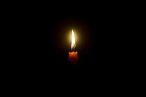 ein Single Verbrennung Kerze Flamme oder Licht glühend auf ein Spiral- Orange cand foto