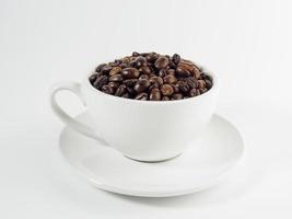 geröstet Arabica Kaffee Bohnen, bereit zu machen Kaffee Das Menschen mögen zu trinken. platziert im ein Weiß Kaffee Tasse auf das Hintergrund. sieht aus schön und appetitlich. trinken. foto