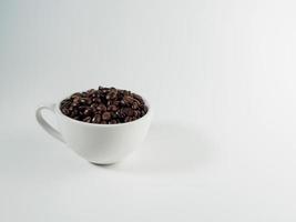 geröstet Arabica Kaffee Bohnen, bereit zu machen Kaffee Das Menschen mögen zu trinken. platziert im ein Weiß Kaffee Tasse auf das Hintergrund. sieht aus schön und appetitlich. trinken. foto