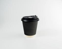 Vorderseite oben Sicht, schwarz Kaffee Papier Tasse schwarz Deckel, gefüllt mit heiß schwarz Kaffee Amerikaner, Nein Zucker Milch, bereit zu trinken, erfrischend. Aroma Erwachen frisch zu Arbeit platziert auf ein Weiß isoliert Hintergrund foto