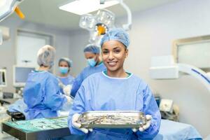 Chirurgin in chirurgischer Uniform, die chirurgische Instrumente im Operationssaal nimmt. junge Ärztin im Operationssaal des Krankenhauses foto