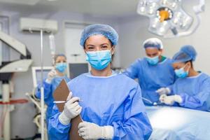 der Chirurg Schreiben auf Zwischenablage im Betrieb Zimmer, Anästhesist Schreiben das Aktualisierung foto