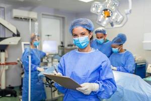 der Chirurg Schreiben auf Zwischenablage im Betrieb Zimmer, Anästhesist Schreiben das Aktualisierung foto