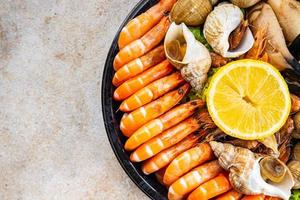 Meeresfrüchte Teller sortiert Garnelen, Krabbe Krallen, Venusmuscheln, Rapan, Trompeter Weichtier Mahlzeit Essen Snack auf das Tabelle Kopieren Raum Essen Hintergrund rustikal oben Aussicht foto