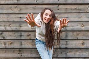 glückliches Mädchen lächelt. Schönheitsporträt junge glückliche positive lachende brünette Frau auf Holzwandhintergrund foto