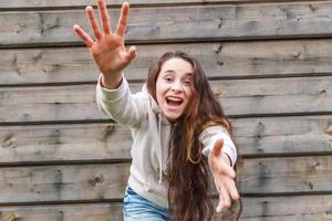 glückliches Mädchen lächelt. Schönheitsporträt junge glückliche positive lachende brünette Frau auf Holzwandhintergrund foto