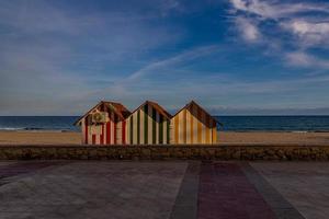 friedlich Strand Landschaft mit drei bunt hölzern Häuser Strand und Ferien foto