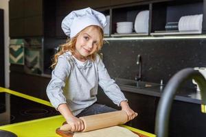 wenig Mädchen vorbereiten Teig, backen hausgemacht Urlaub Apfel Kuchen im Küche foto