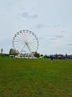 niedrig Winkel Aussicht von Willen See und Öffentlichkeit Park mit Ferris Rad zum Spaß. Menschen sind genießen das Start von Sommer- Jahreszeit beim diese Park von Milton Schlüssel England Vereinigtes Königreich. Aufnahmen war gefangen auf 09. April 202 foto