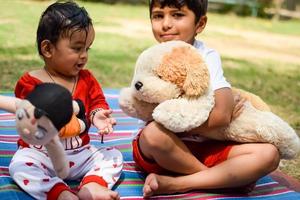 zwei glücklich Jungs im Gesellschaft Park, glücklich asiatisch Brüder Wer sind lächelnd glücklich zusammen. Brüder abspielen draußen im Sommer, Beste Freunde. Kleinkind Baby Junge spielen mit seine glücklich Bruder im das Garten foto