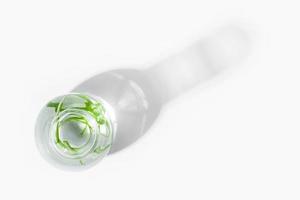 organisch Kosmetika, natürlich Kosmetika, Biokraftstoffe, Algen. natürlich Grün Labor. Experimente. Glas Labor Flasche mit Grün Pflanzen auf ein Licht Hintergrund. foto