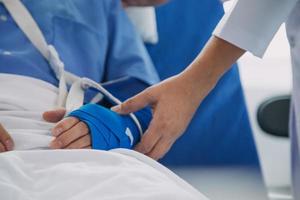 verletzt geduldig zeigen Arzt gebrochen Handgelenk und Arm mit Binde im Krankenhaus Büro oder Notfall Zimmer. Verstauchung, Stress Fraktur oder repetitiv Belastung Verletzung im Hand. Krankenschwester Portion Kunde. zuerst Hilfe. foto