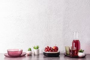 Küche Hintergrund mit modern Utensilien, Krug mit Traube Saft, ein Ast von Trauben auf ein Platte. immer noch Leben. Vorderseite Sicht. ein Kopieren Raum. foto