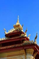 golden Naga auf Kunst Dach von Buddhist Tempel mit Blau Himmel im wat pha Das luang Tempel Wien Provinz, Laos foto