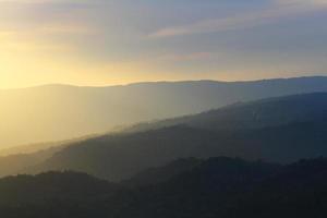 schön Landschaft Schichten von Berg und neblig auf Hügel Senke im golden Dämmerung von Sonnenuntergang beim Thailand foto