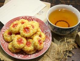 hausgemacht Daumenabdruck Erdbeere Marmelade Kekse und Tee foto