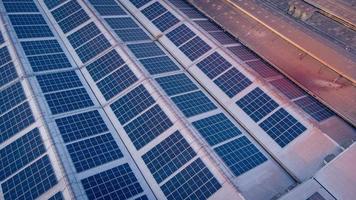 ein groß Solar- Zelle Dach auf ein industriell Gebäude Erstellen Elektrizität zum das Pflanze während tagsüber gemäß zu Richtlinien und Maße zu reduzieren global Erwärmen durch nehmen hoher Winkel Schüsse von Drohnen foto