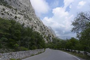 ein gepflastert Straße entlang felsig Berge mit ein gefährlich Kurve. Landschaft. foto