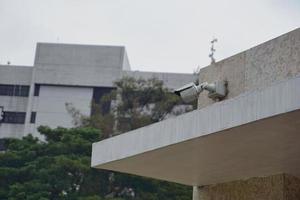 einer Weiß aktiv Überwachungskamera, welche ist stecken auf das Mauer im das Hof foto