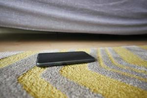 vergessen Smartphone auf Fußboden beim Zuhause foto