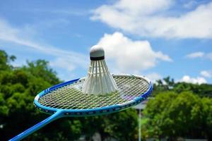 Weiß Sahne Badminton Federbälle auf Badminton Schläger, verschwommen Bäume Hintergrund, Konzept zum draussen Badminton spielen im kostenlos mal, Sanft und selektiv Fokus. foto