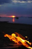 Lagerfeuer mit Sonnenuntergang auf das Strand wie ein Hintergrund. foto