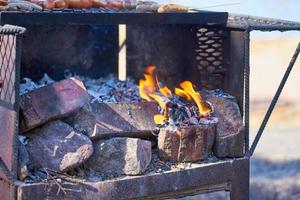 Feuer in einem rostigen Weinlesegrill im Freien mit unscharfem Hintergrund foto