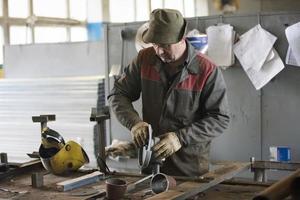 Arbeiter im ein Werkstatt mit ein Schleifer. foto