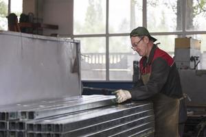 Arbeiter im ein Werkstatt mit Metall Belüftung Rohre. foto