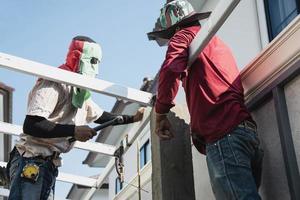 vor Ort Konstruktion Arbeiter mit Stahl Dach Struktur Installation, Wohn Gebäude Auftragnehmer Job foto