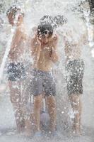 Kinder baden im ein Brunnen. Jungs auf ein heiß Tag beim das Stadt Brunnen. foto