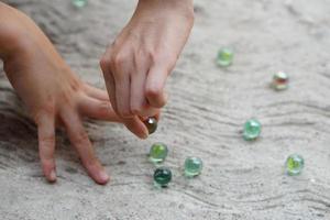 Nahansicht Kind Hände abspielen Marmor Glaskugeln. Konzept, traditionell Kinder abspielen Spielzeug. Erholung Aktivität zu machen konzentrieren zum Kinder, Spaß und Wettbewerb Spiele foto