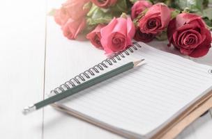 leer Notizbuch mit Bleistift und rot Rose foto