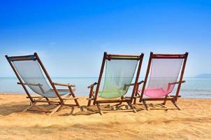 Bambus Deck Stühle auf das sandig Strand mit hell Sonne und Wellen, Insel Süd von Thailand. entspannend Tag beim das Strand foto