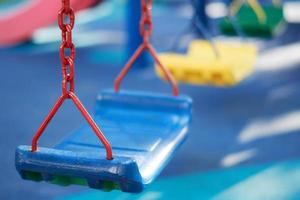 schließen oben von leeren Kinder schwingen auf Kinder Spielplatz im das draussen Park im das Weicher Fokus Hintergrund foto