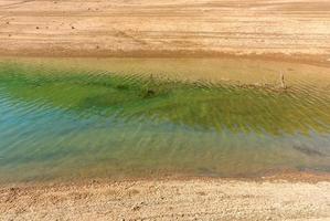 Grün Wasser und trocken Boden foto