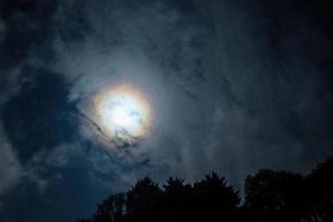 Wolken bestehen im Vorderseite von das Mond im ein Nacht Himmel. foto