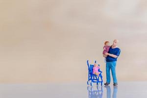 Miniaturmenschen, Vater, der ihre niedliche kleine Tochter in den Armen mit Kopienraum für Text hält, Vatertagskonzept foto