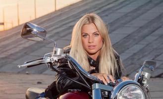 sexy Blondine sitzt auf ihrem Motorrad