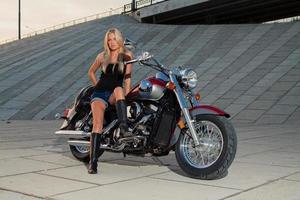 sexy Blondine sitzt auf ihrem Motorrad