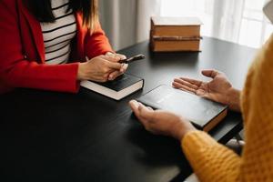 zwei menschen lesen und studieren die bibel zu hause und beten zusammen. das wort gottes mit freunden studieren. foto