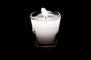 Kerze im Glas auf schwarzem Hintergrund foto