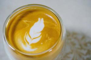 hausgemachte heiße Kaffee Latte Kunst und Milchschaum, perfekter Cappuccino in einer weißen Tasse auf weißem Hintergrund. Nahaufnahme und Makrofotografie. foto