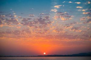 bunter Sonnenuntergang in einem bewölkten Himmel über einem Gewässer foto